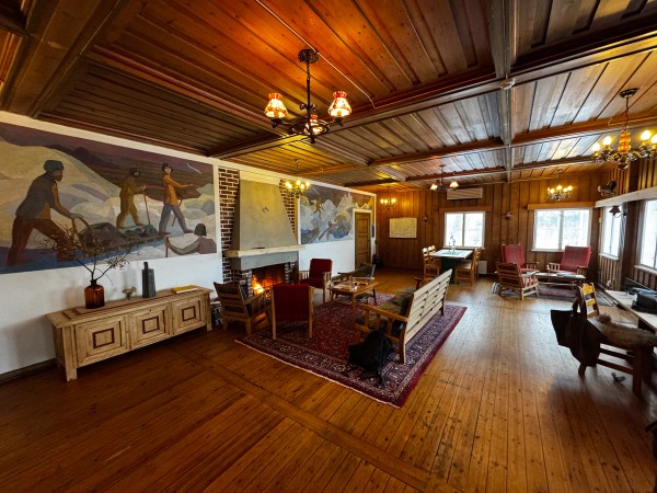 The living room and fireplace at Voss Mountain Lodge, with murals of Fridtjof Nansen.