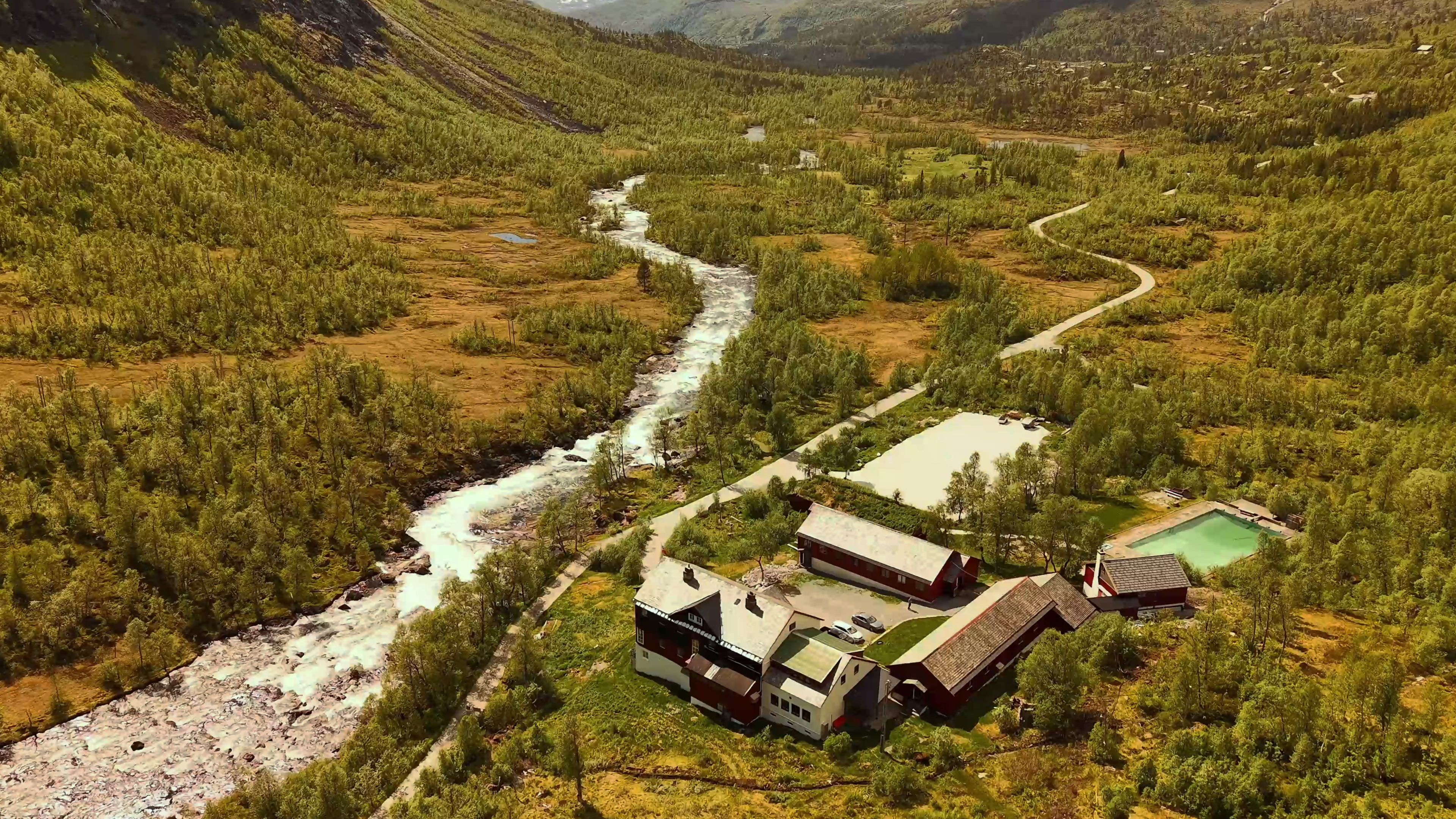 An aerial view of Arctic Coliving in Voss Norway with mountains and a mountain lodge