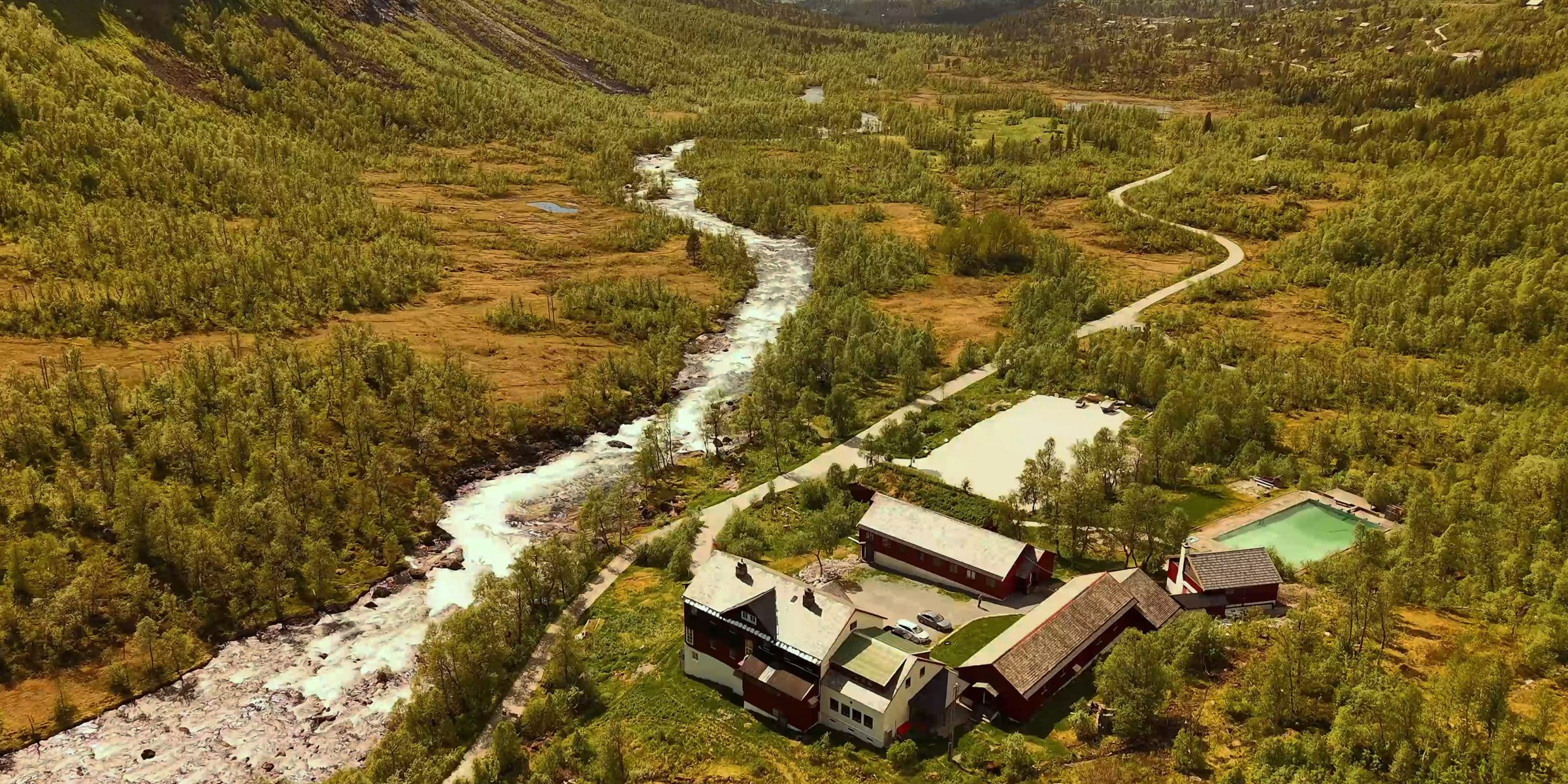 An aerial view of Arctic Coliving in Voss Norway with mountains and a mountain lodge