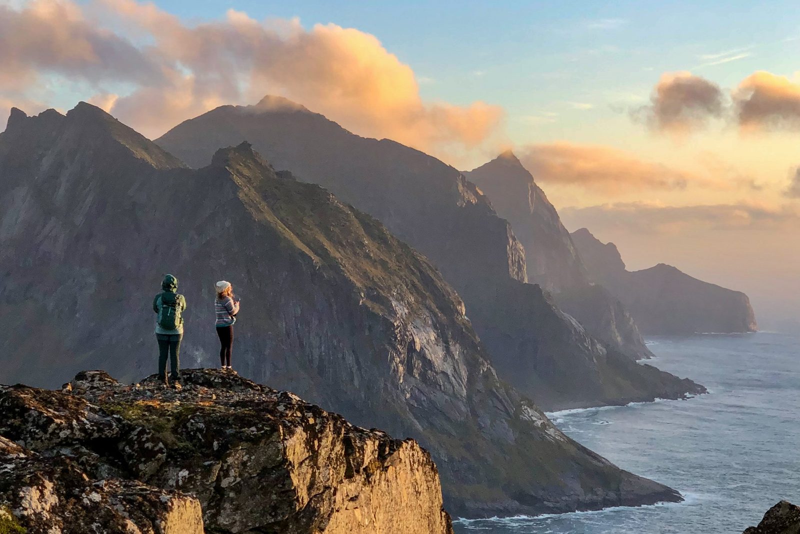 Hikers in the mountains of Lofoten at sunset