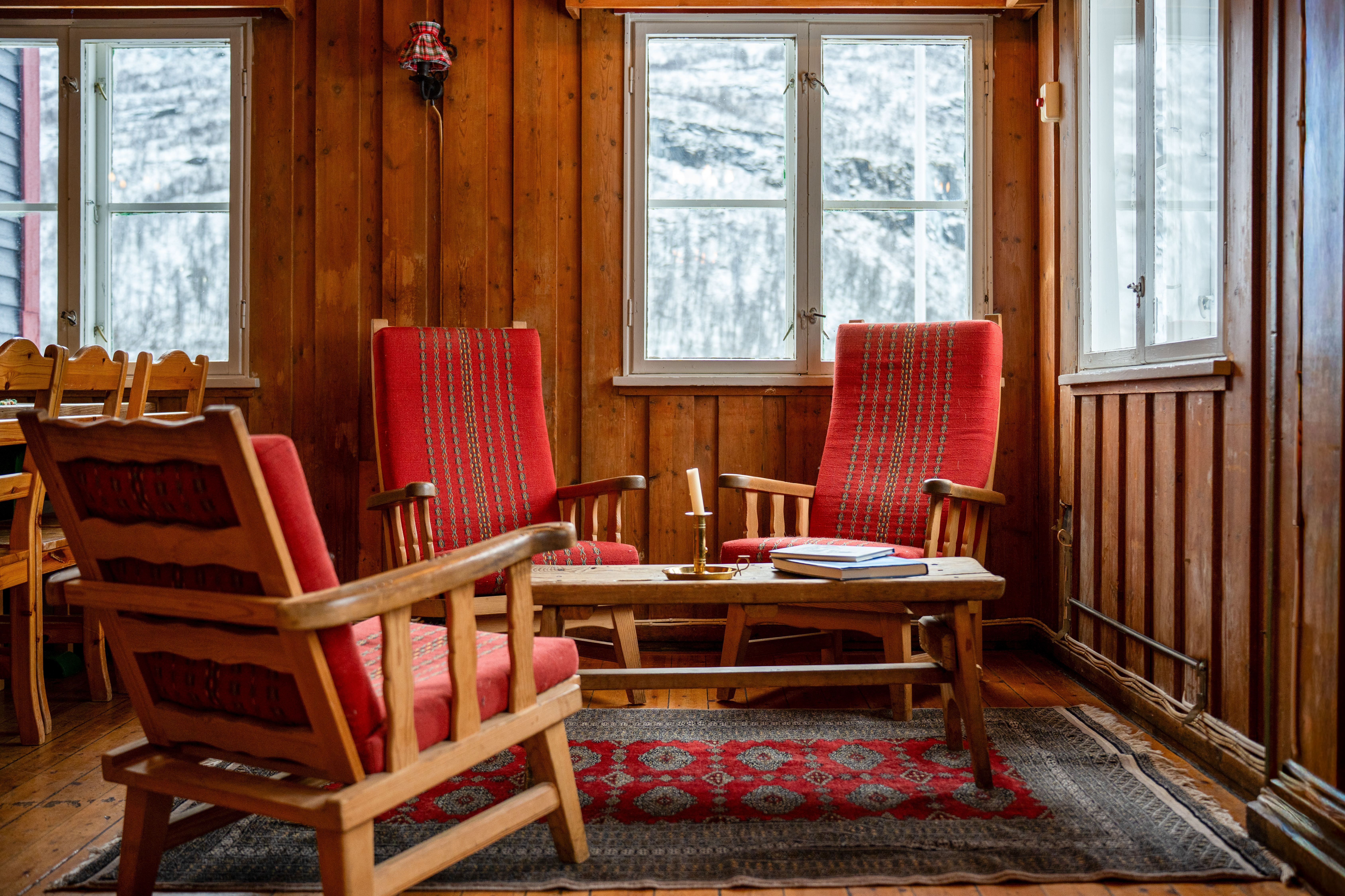 Arctic Coliving - a cozy living room with rustic wooden walls and lounge chairs in the mountains of Norway in winter