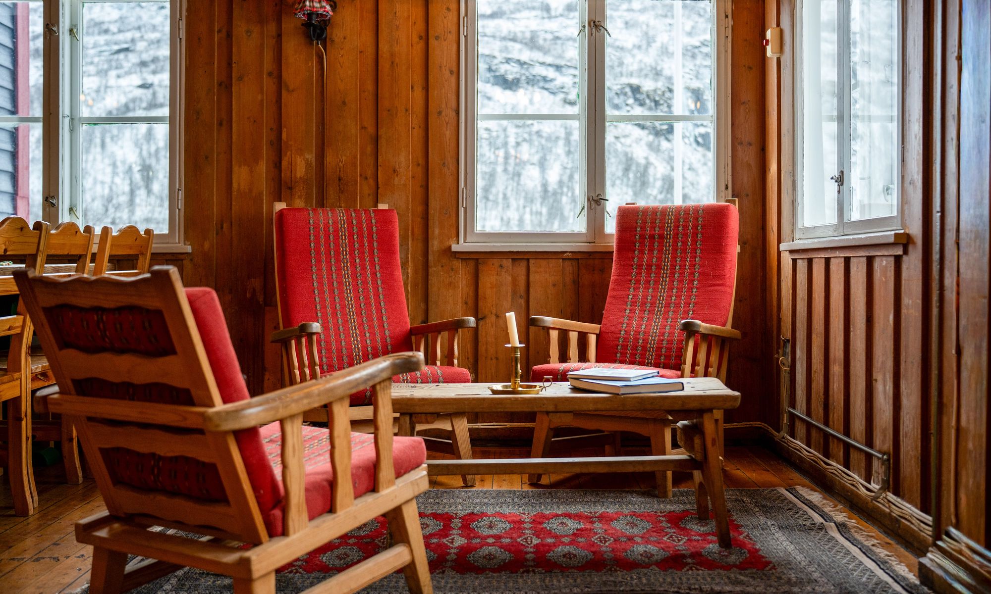 Arctic Coliving - a cozy living room with rustic wooden walls and lounge chairs in the mountains of Norway in winter