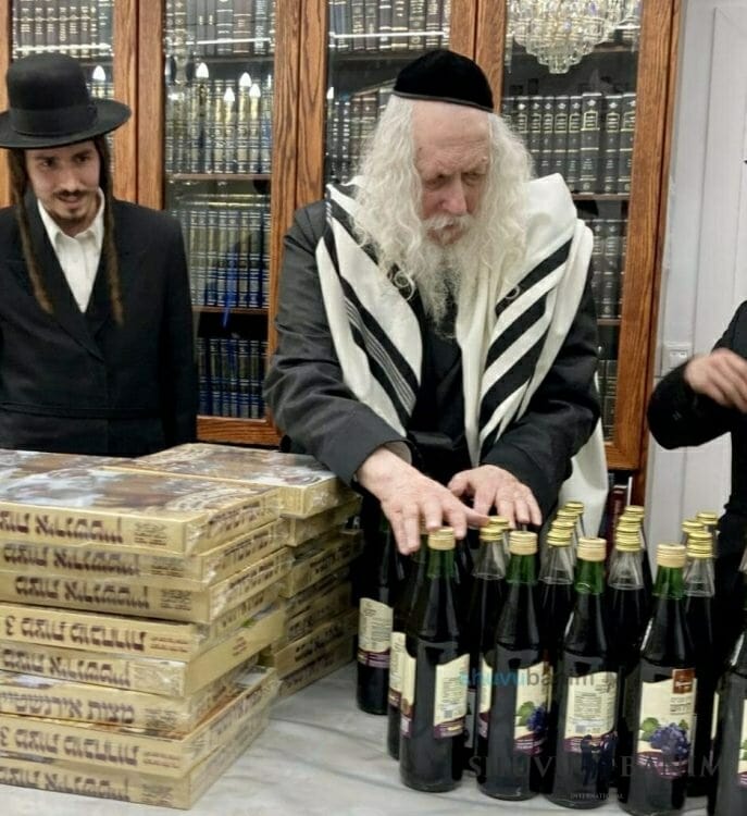 R' Eliezer Berland Shlit"a Blesses Wine and Matzas for Families of "HaBen Yakir Li"