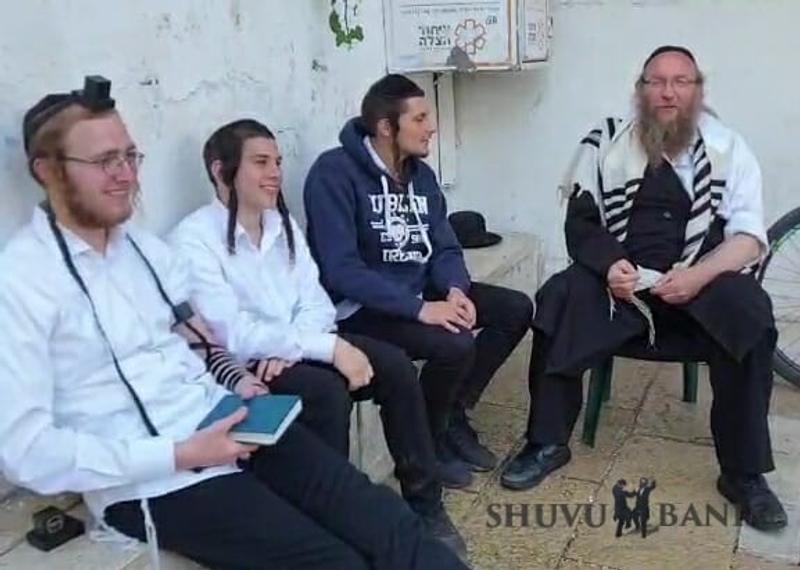 זלמן גרוסמן בשיחה עם חסידי הרב ברלנד שהצילו אותו ממכות בקבר שמעון הצדיק