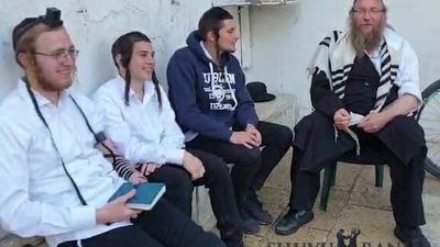 זלמן גרוסמן בשיחה עם חסידי הרב ברלנד שהצילו אותו ממכות בקבר שמעון הצדיק