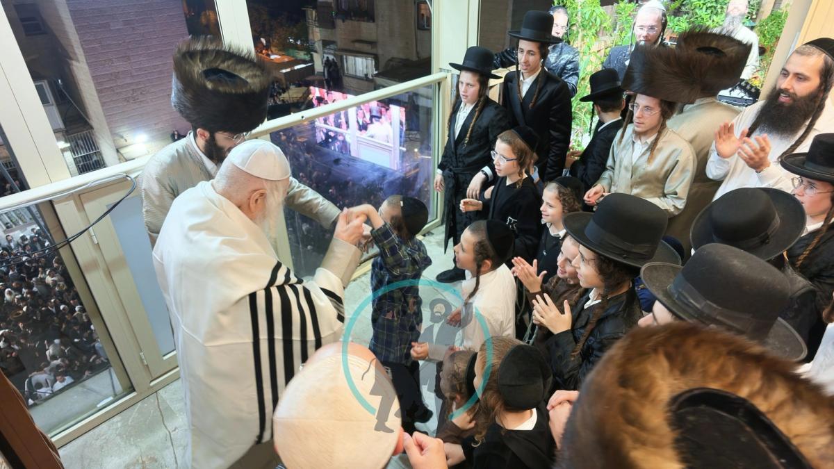 נכדי הרב אליעזר ברלנד רוקדים עמו על המרפסת בליל הילולת רבי נחמן