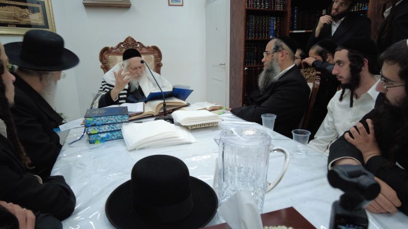 מורנו הרב ברלנד שליט"א לומד מתוך הספר; לידו יושב הרב יעקב אמזלג ראש הישיבה