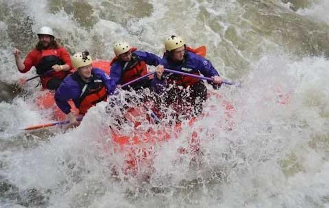 White water rafters an inflatable boat in a Maryland river. 