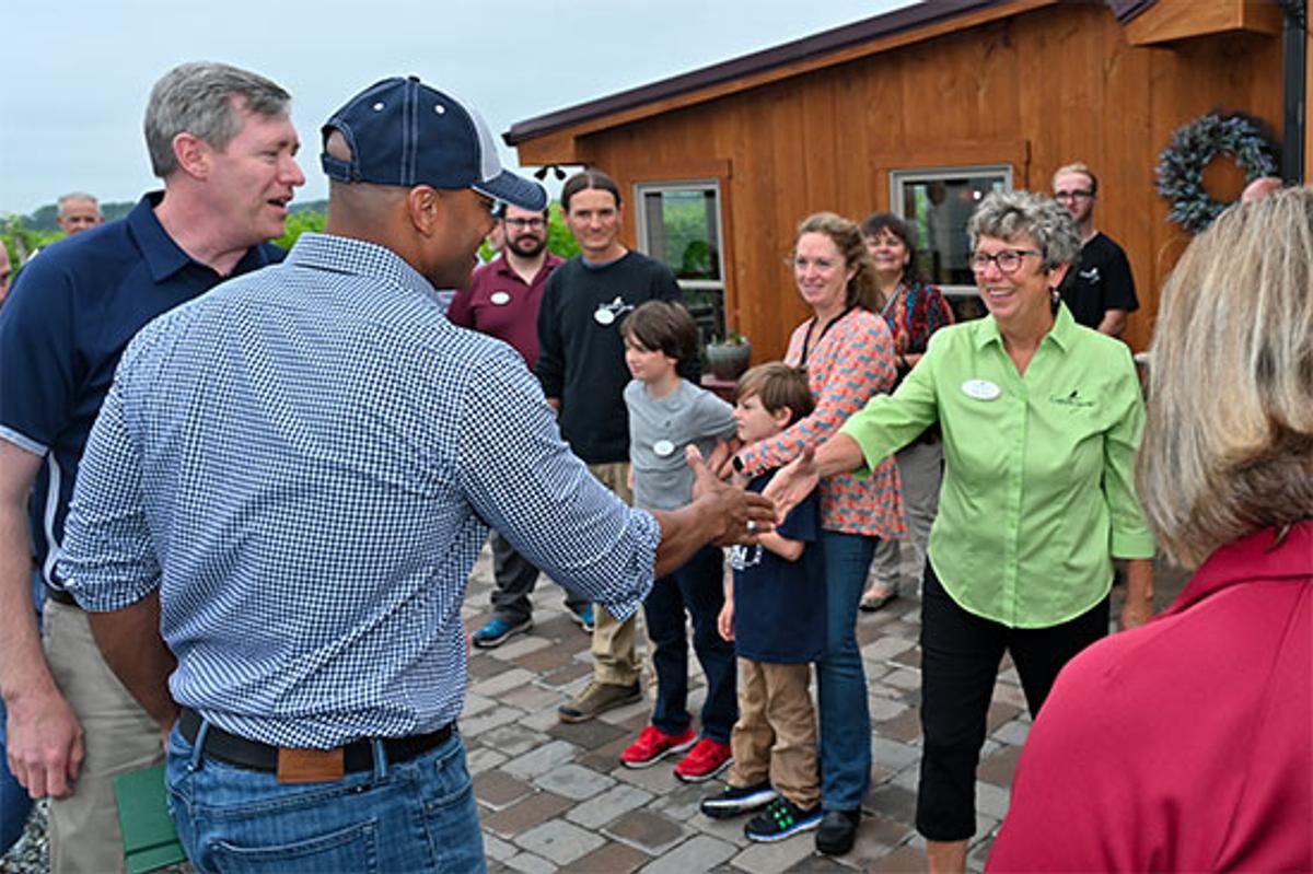 Governor Wes Moore shakes hands with Crow Vineyard & Winery leadership