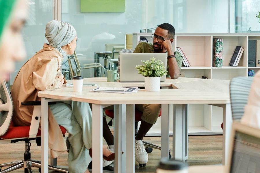 Colleagues working at shared desks in a bright office