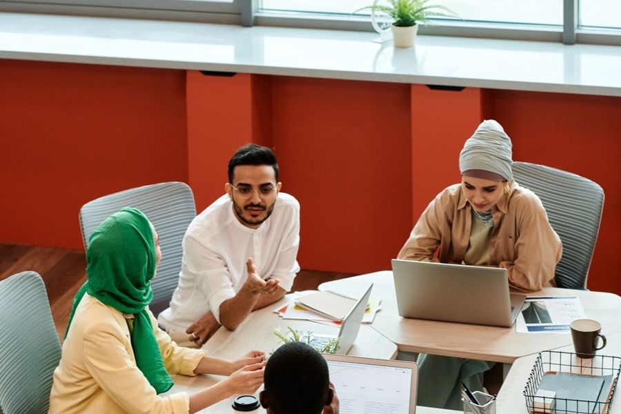 A team working together round a table with laptops