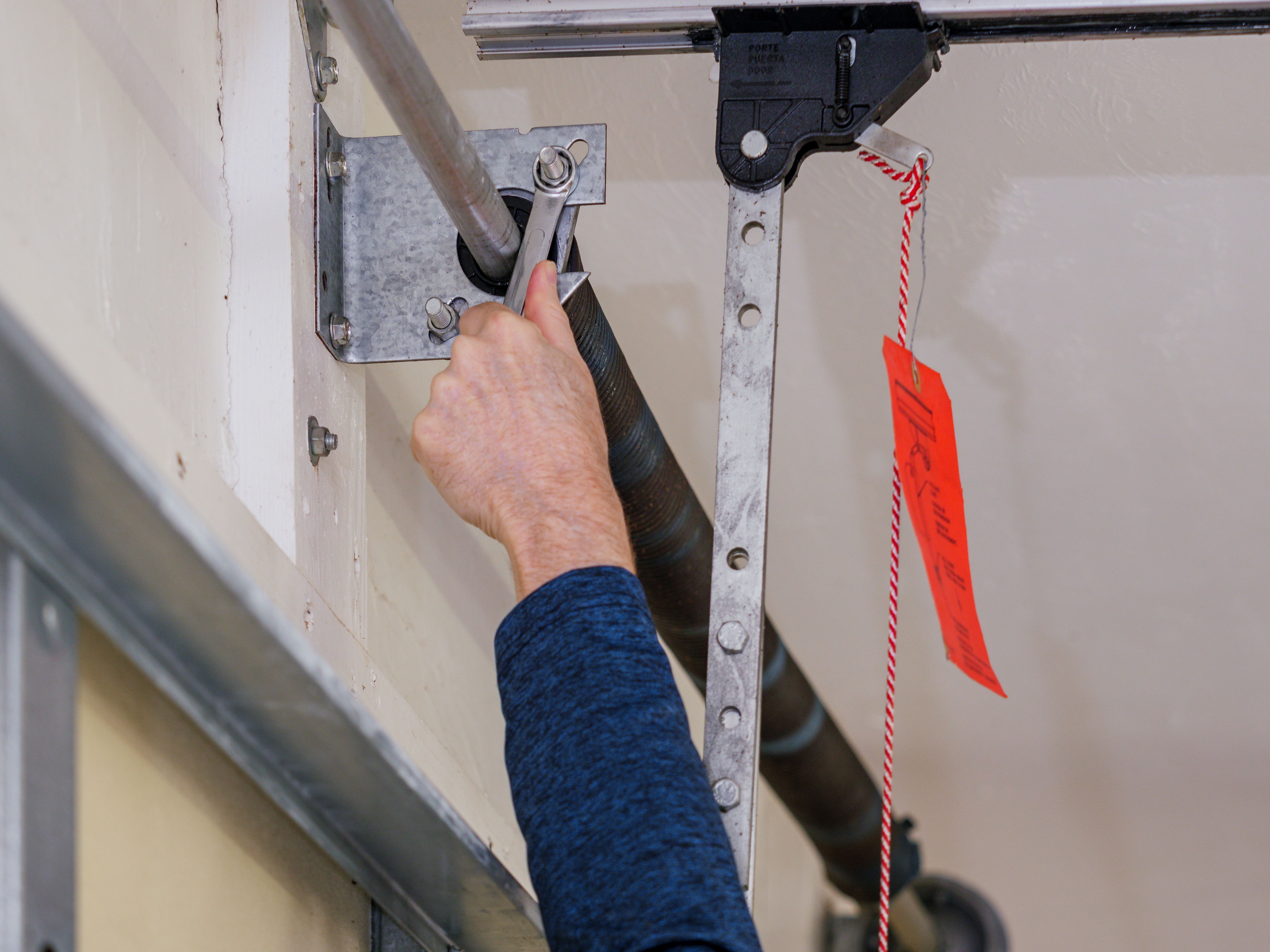 Technician repairing a broken garage door spring