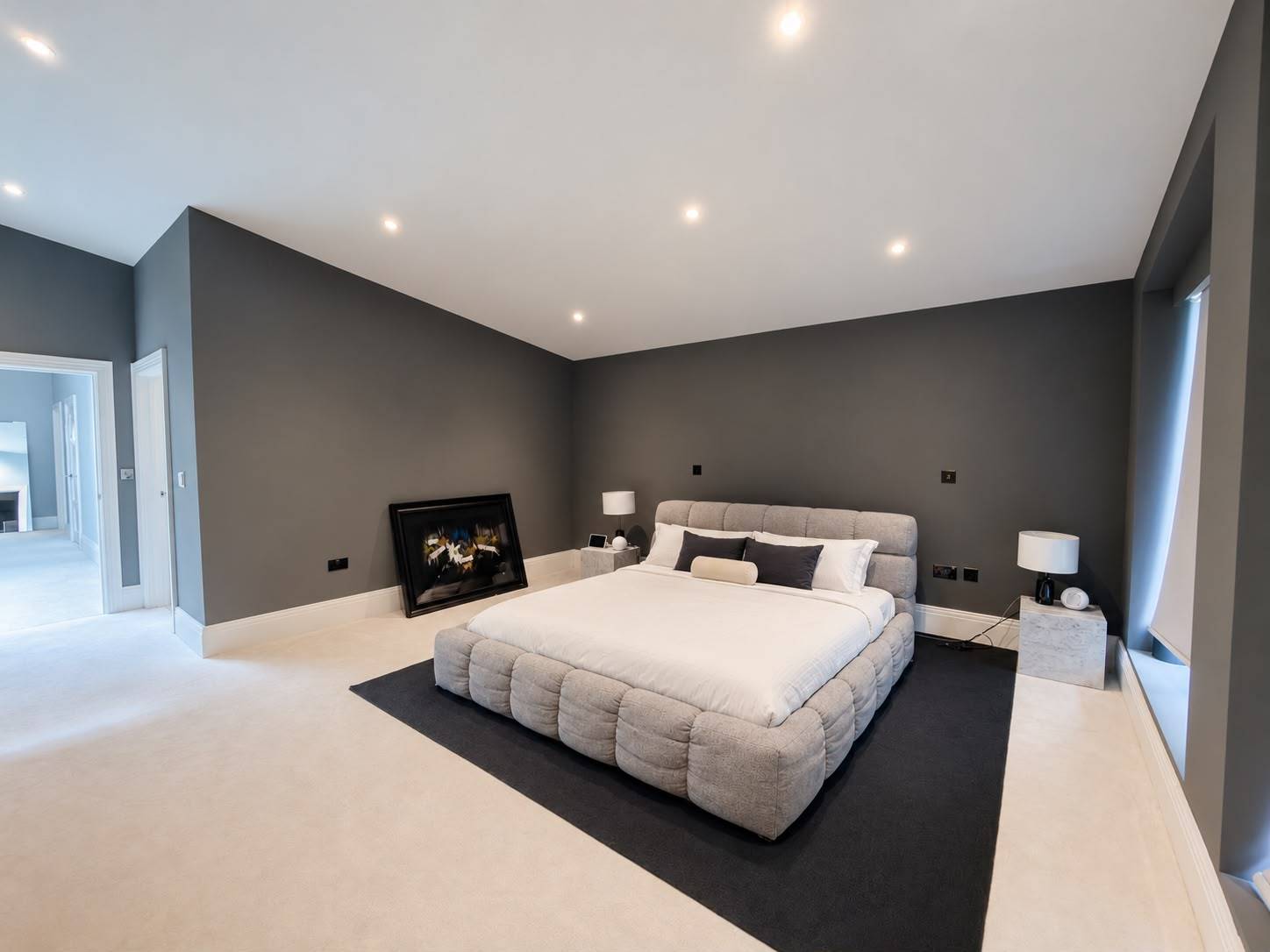 Sleek modern master bedroom location house in Barnet EN4 through Love Locations, featuring a dark accent wall, grey upholstered bed, and neutral carpet.