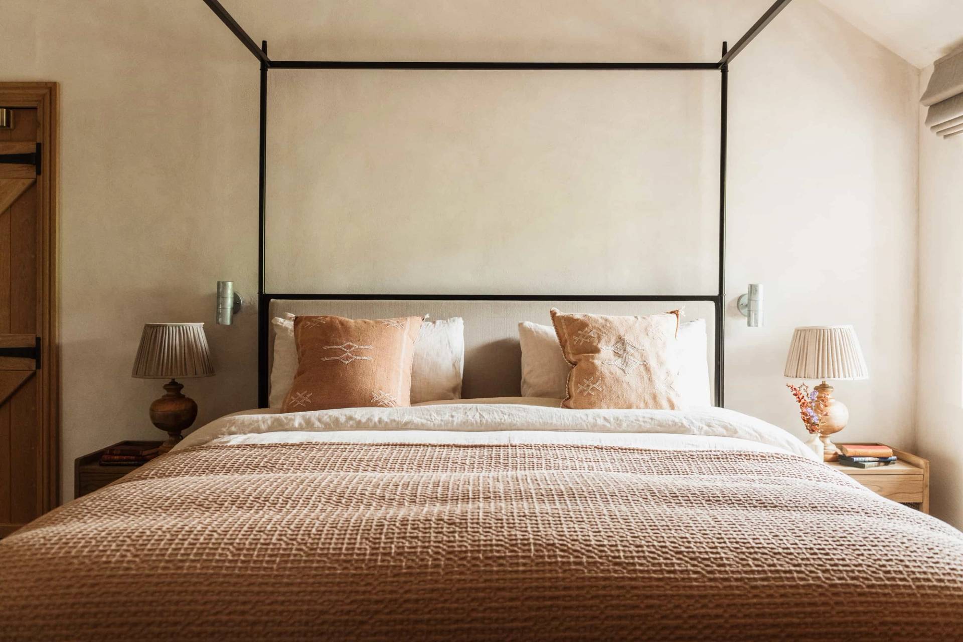 Four-poster bed master bedroom shoot location in Castleblayney County Monaghan Ireland from Love Locations, featuring a black metal frame, warm neutral bedding, and textured plaster walls.