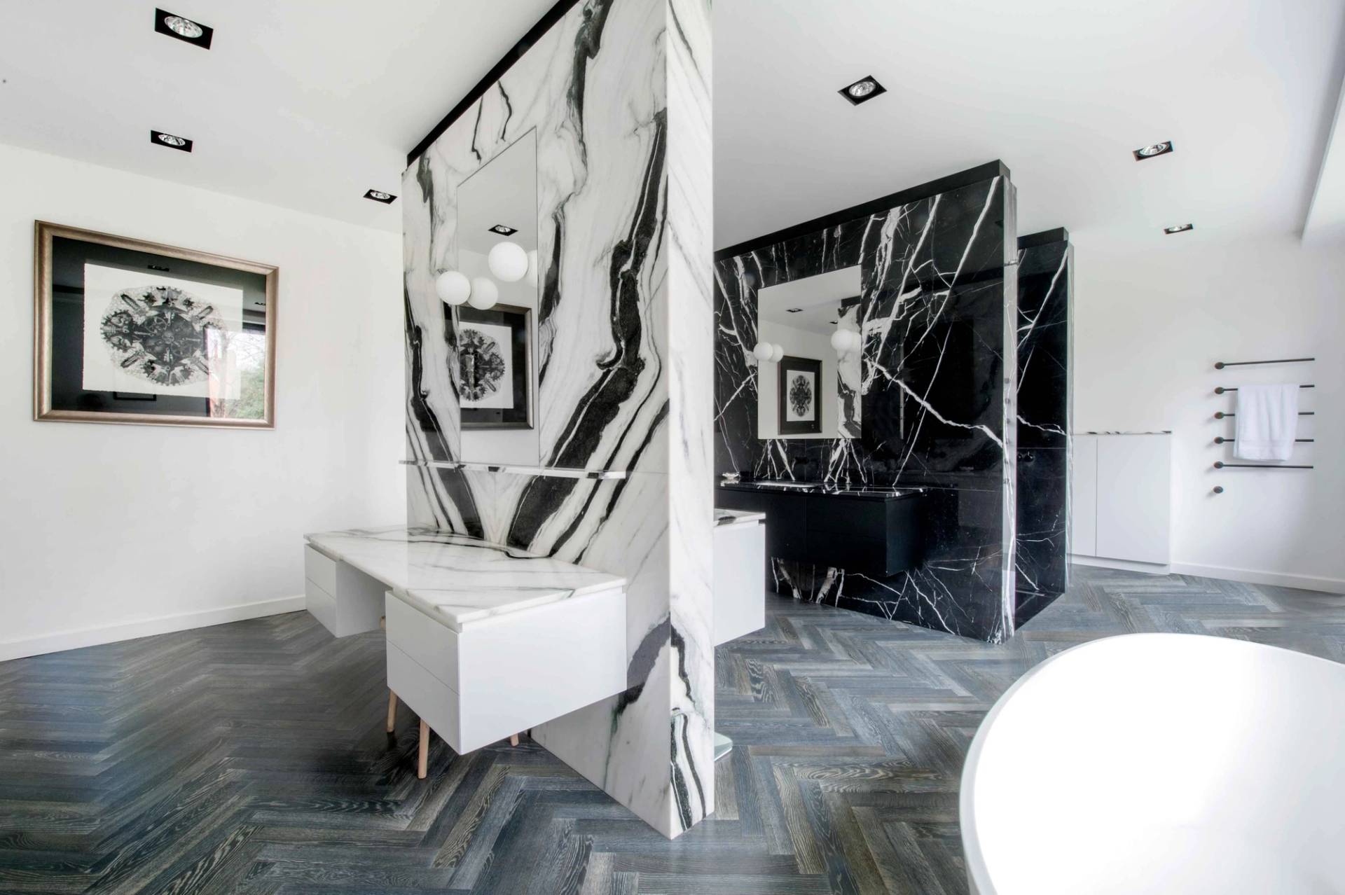 Stunning luxury bathroom featuring a striking black and white marble partition wall framing a double vanity sink setup, Love Locations.
