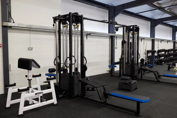 Professional dual-cable crossover machine and strength training apparatus set up in a modern fitness studio, Love Locations SO23.