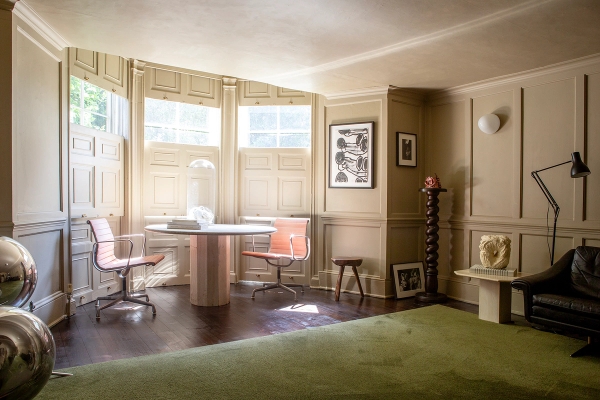 Bay window nook set with a circular dining table, orange swivel chairs, and sash window light, Love Locations ME13.