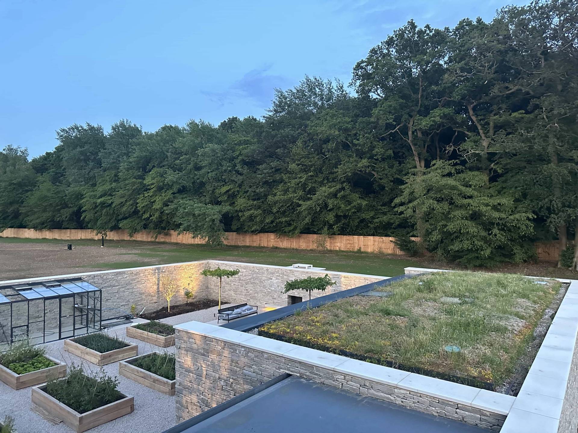 Aerial or upper-level perspective of a modern home showing a green sedum roof system and a structured courtyard garden layout in CM4, the ultimate architectural backdrop via Love Locations.