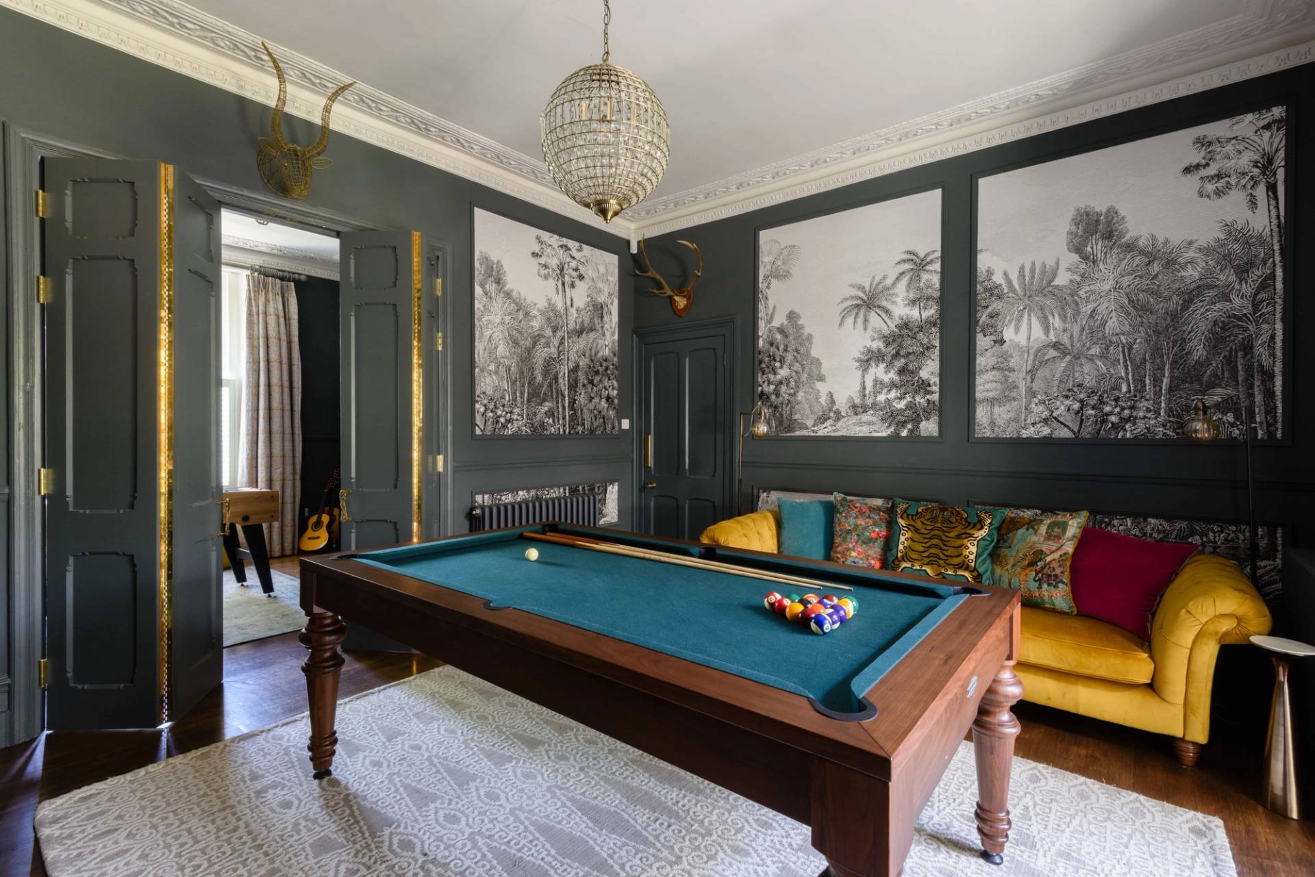 Formal entertainment room featuring a full-size pool table, dark grey panelling, and framed landscape wallpaper, Love Locations TW11.