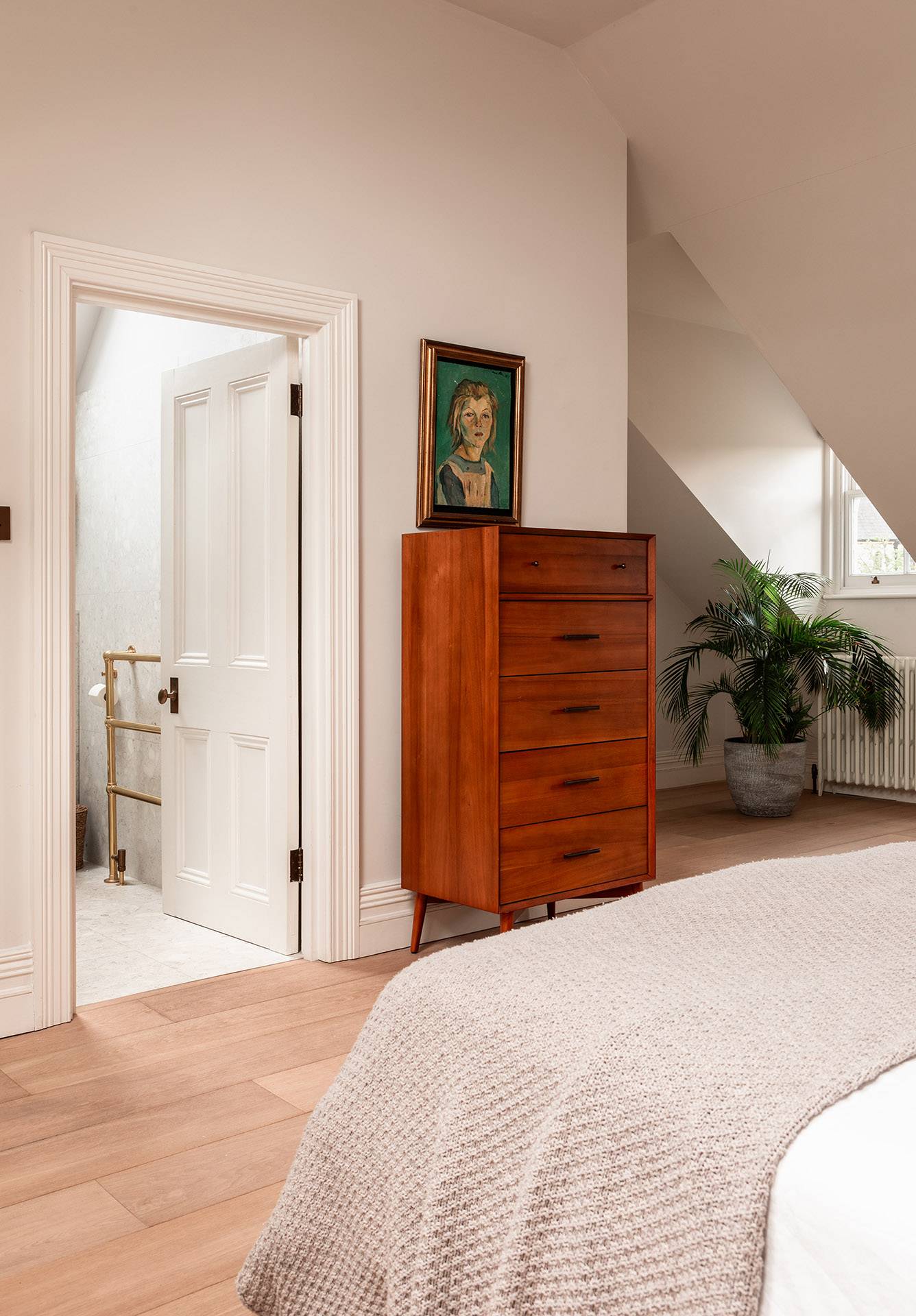 Top-floor bedroom doorway looking across light timber floorboards toward a timber dresser, Love Locations TW1.