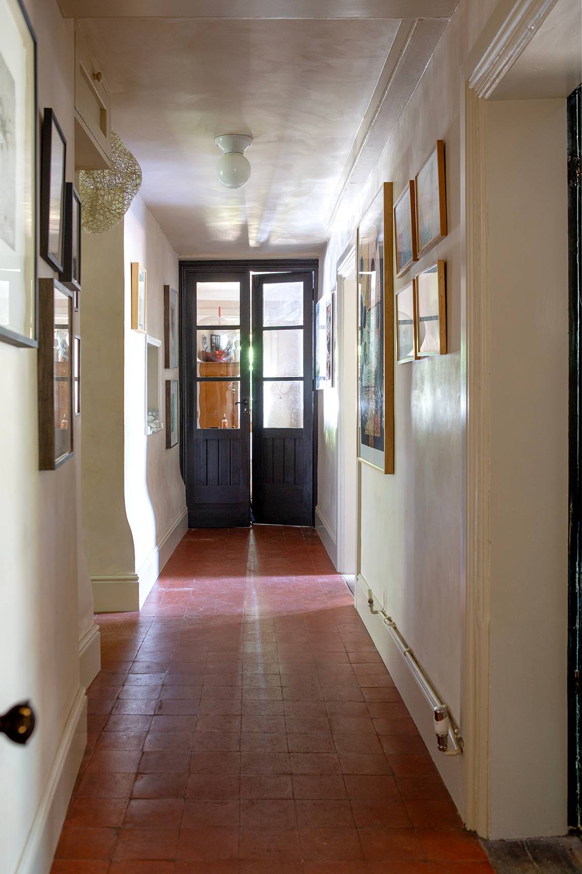 Period hallway corridor with terracotta floor tiles, white wall panelling, and double glazed exit doors, Love Locations ME13.