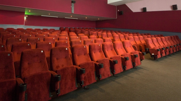 Close-up detail of the plush red velvet theater chairs and carpeted aisle inside The Ritzy Screen 2 commercial filming space from Love Locations.