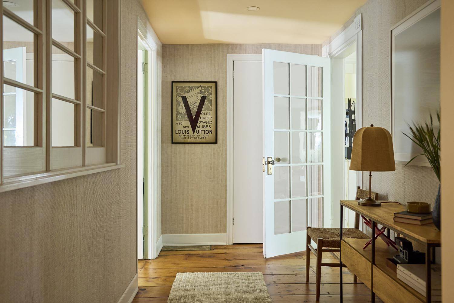 Interior hallway photoshoot venue in a Manhattan NY 10014 garden-level home by Love Locations, displaying white French glass-panelled doors and warm neutral wall colors.