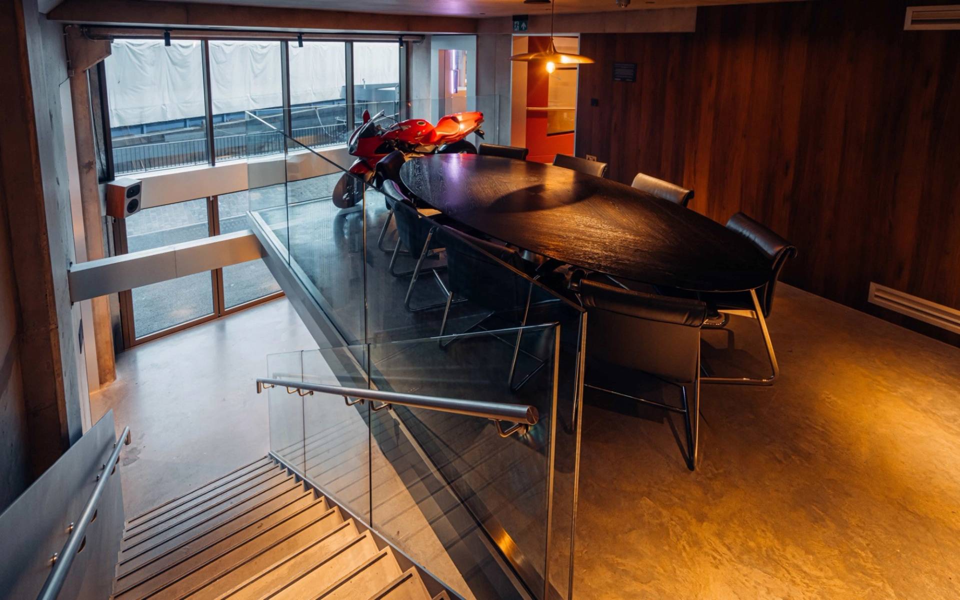 Upper-level meeting table overlooking a supercar venue space in Brentford TW8 via Love Locations.