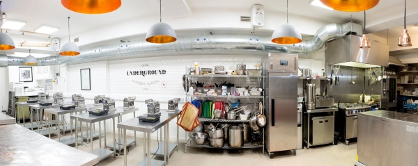 Industrial kitchen shoot space showing open shelving stacked with professional cookware and catering equipment, managed by Love Locations.