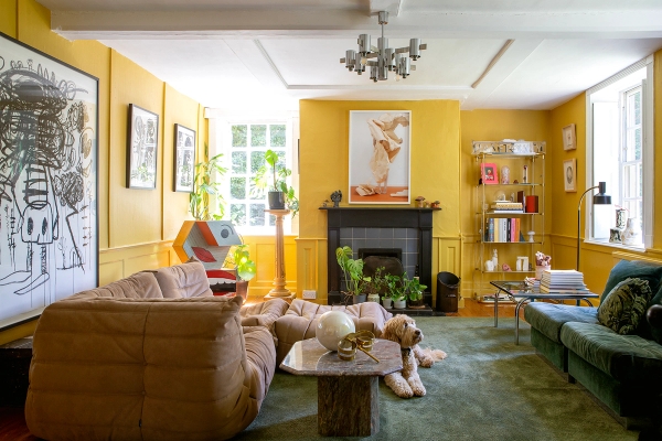 Vibrant living room with mustard yellow panelled walls, open fireplace, and tan velvet seating, Love Locations ME13.