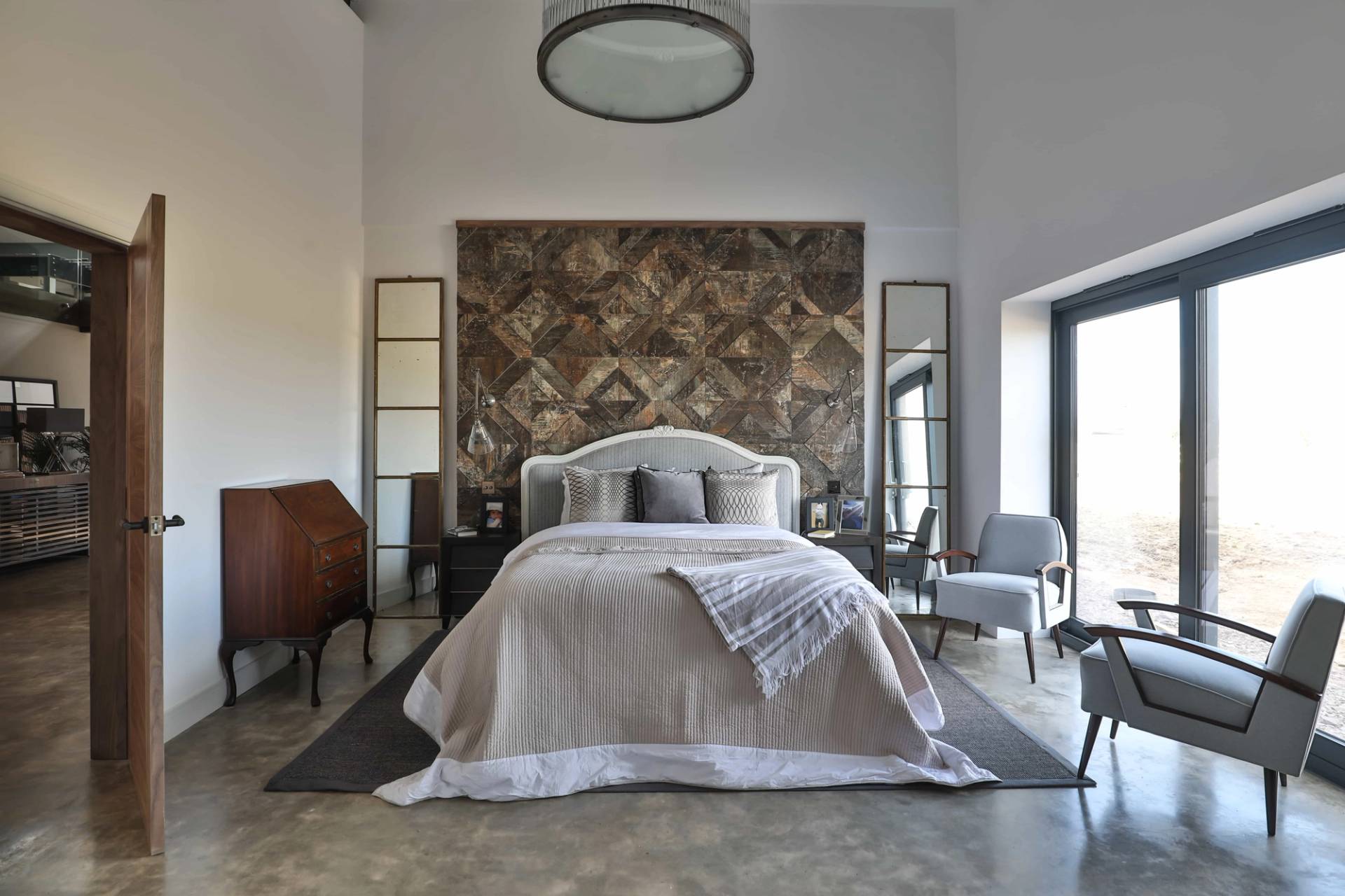 Luxury master bedroom suite featuring a patterned headboard wall, neutral bed linen, and ensuite access, Love Locations CV23.