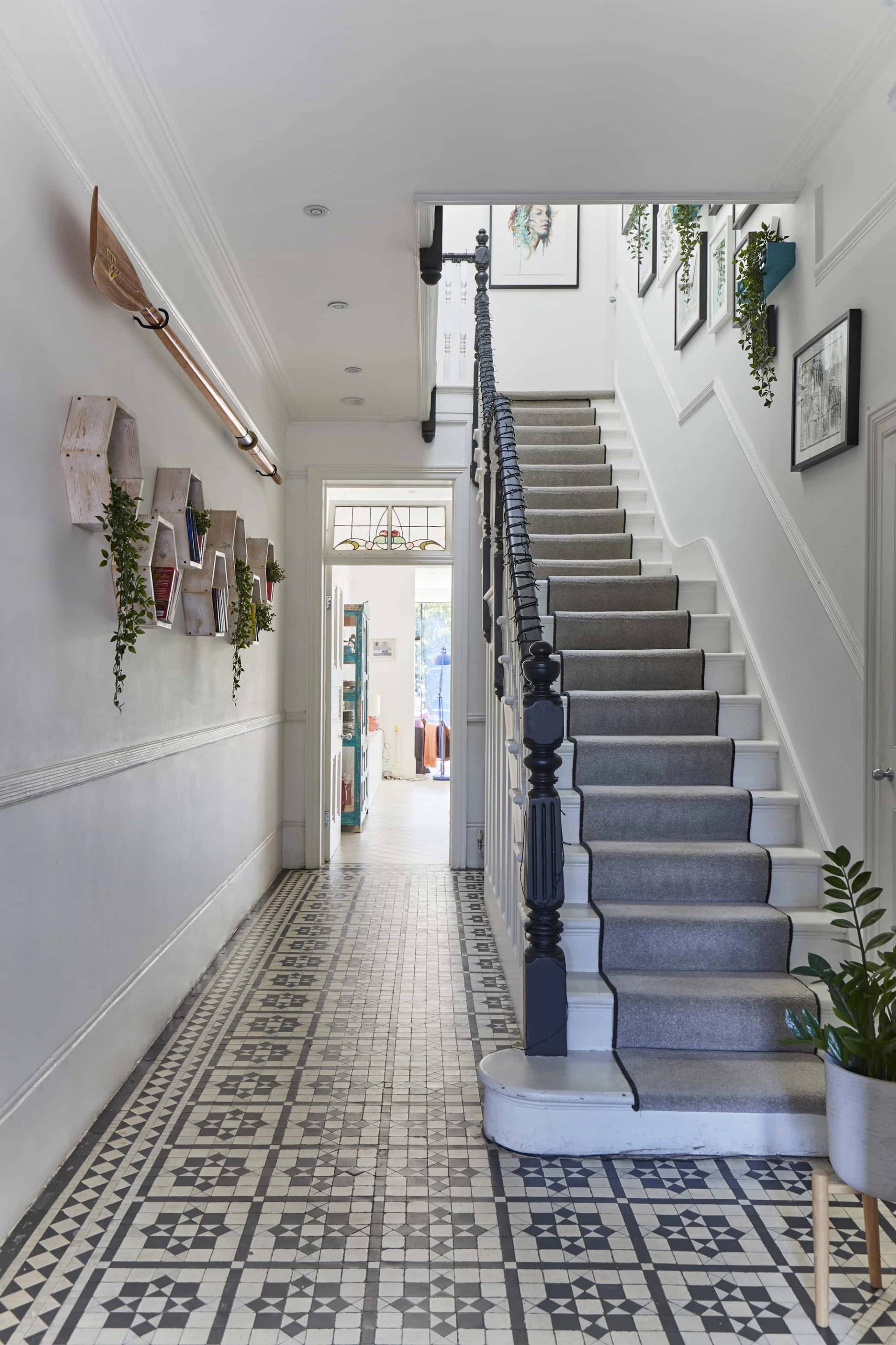 Grand Victorian hallway featuring black wood staircase balustrades, grey stair runner, and monochrome geometric floor tiles, Love Locations W3.