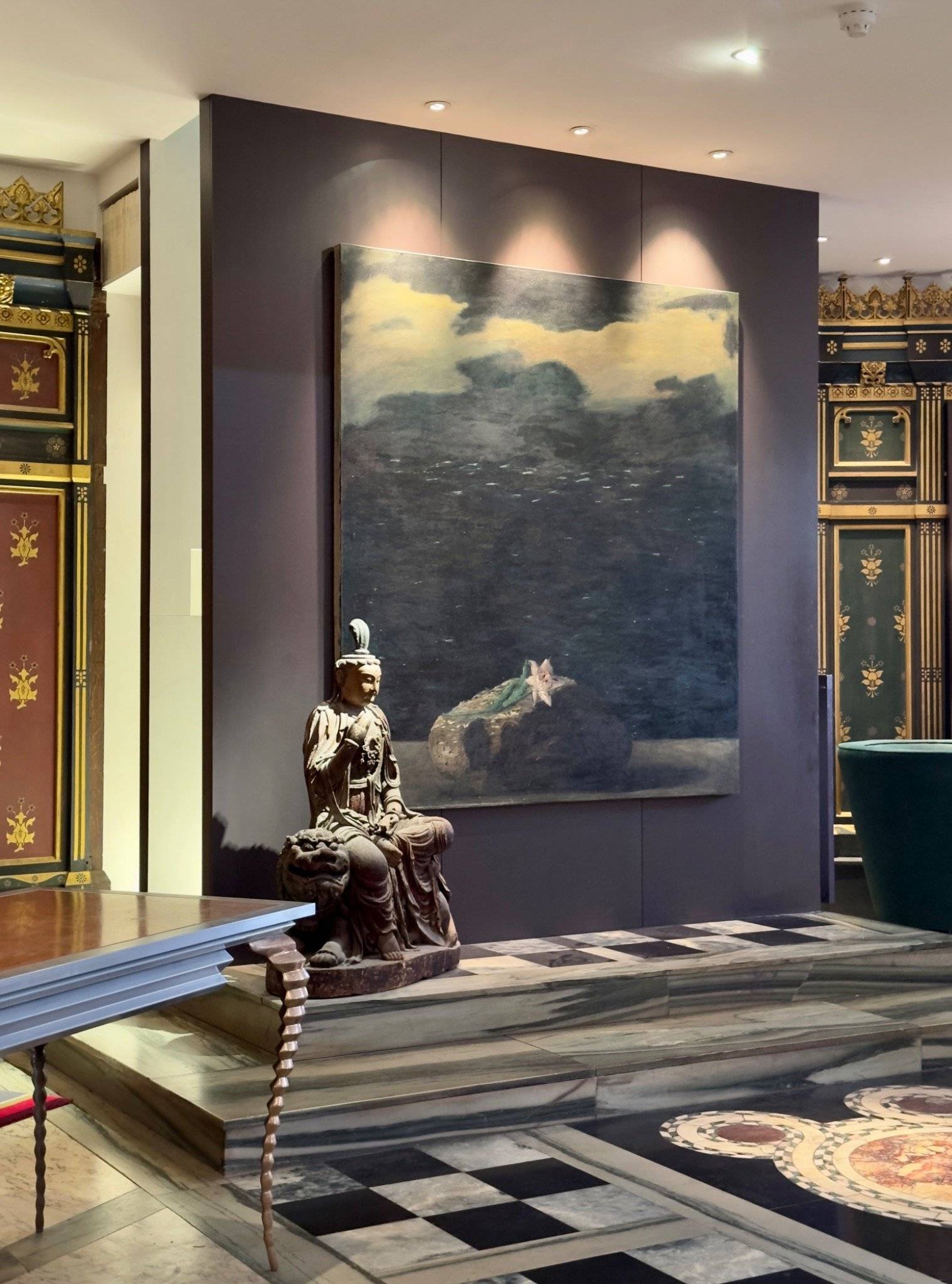 Editorial corner displaying a large landscape painting on a dark feature wall with polished marble flooring in an Oval SE5 shoot location from Love Locations.