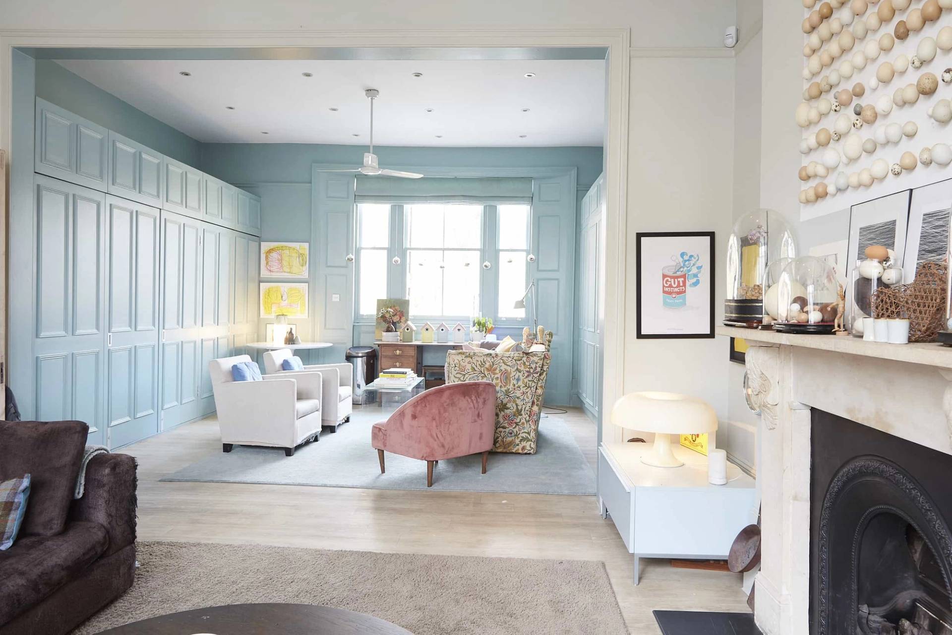 Dual reception room view showing a duck-egg blue panelled library room opening into a bright sitting room, ideal for film scenes, Love Locations N5.