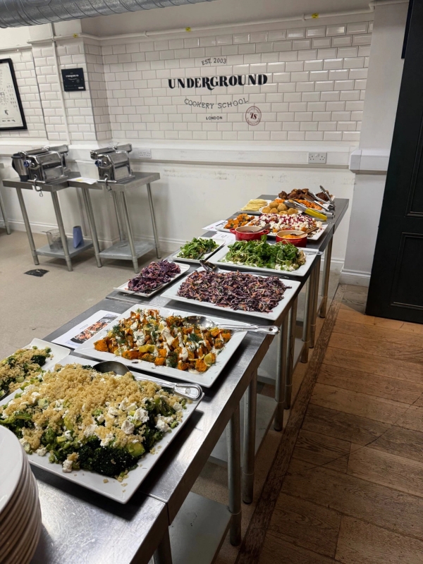Bespoke buffet food display on stainless steel counters for corporate dining and culinary venue hire, listed with Love Locations.