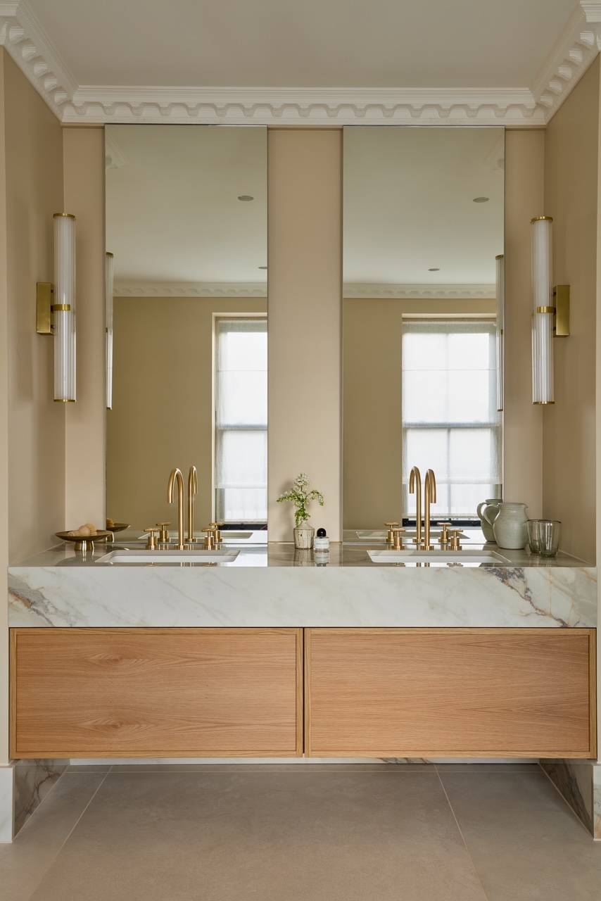 Bespoke double bathroom vanity with marble countertops, dual mirrors, and contemporary fluted brass wall lighting, ideal for premium skincare advertising, Love Locations.