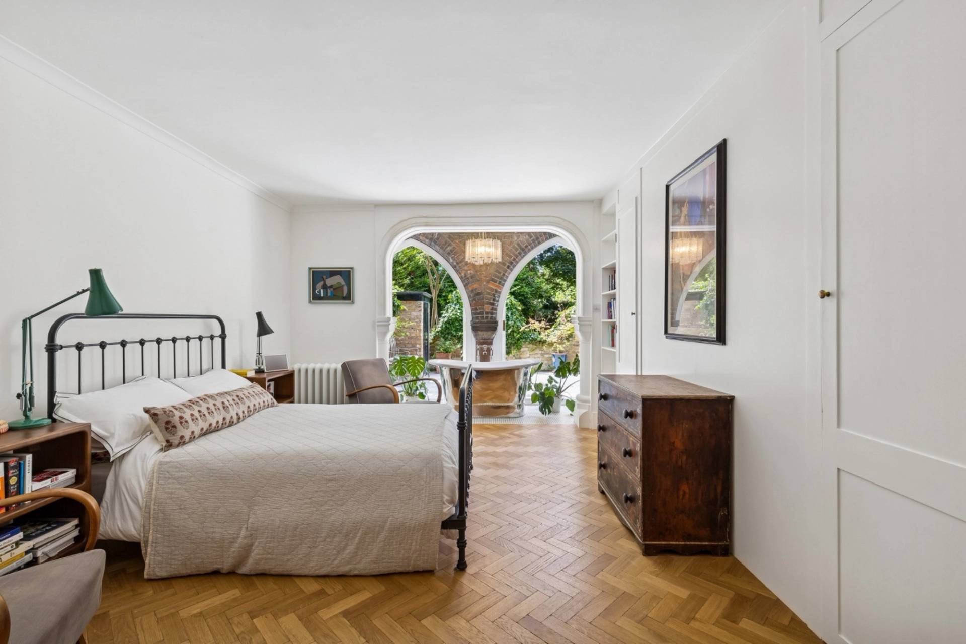 Master bedroom shoot space in a Hampstead NW3 house featuring a black iron bed frame and parquet floors, through Love Locations.