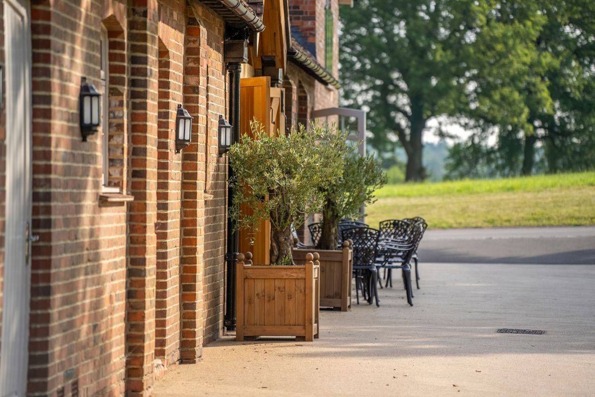 Classic English country house architecture with outdoor seating area, available for commercial venue hire through Love Locations.