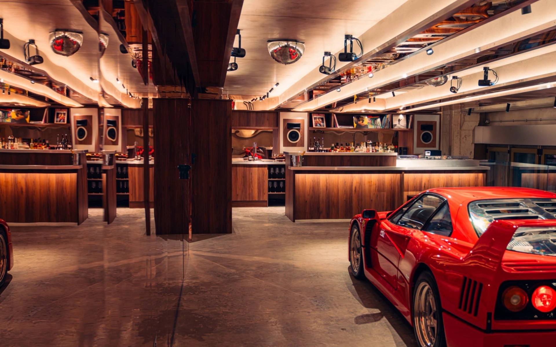 Warm wood-panelled bar interior with a classic red Ferrari parked inside from Love Locations.