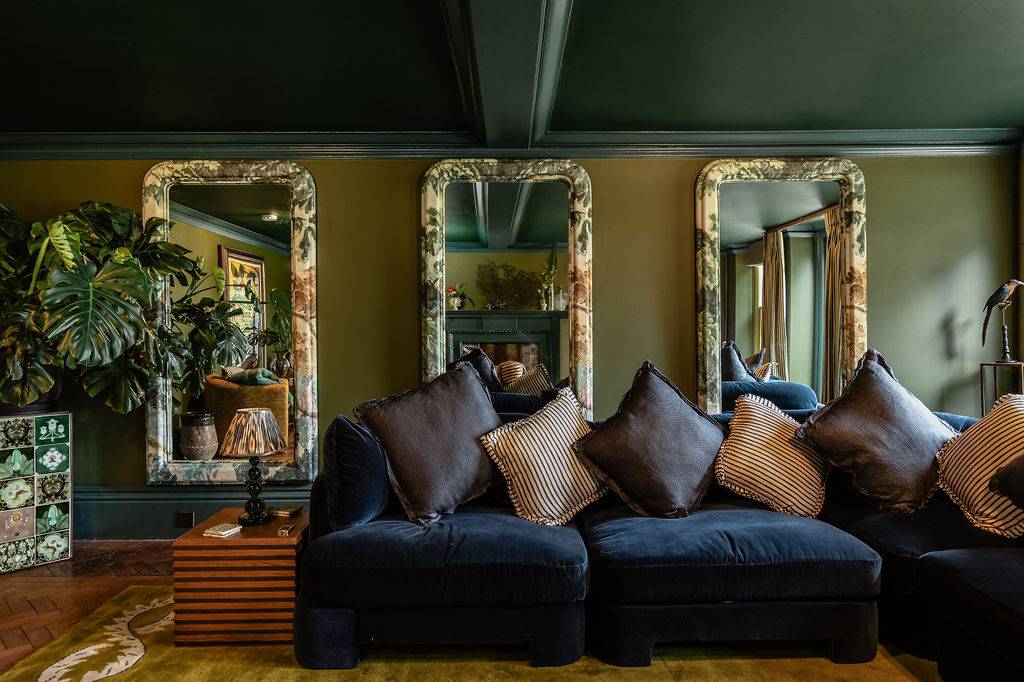 Sumptuous dark velvet lounge sofa framed by heavy gilded wall mirrors, a luxury editorial backdrop in Liss Hampshire GU33 by Love Locations.