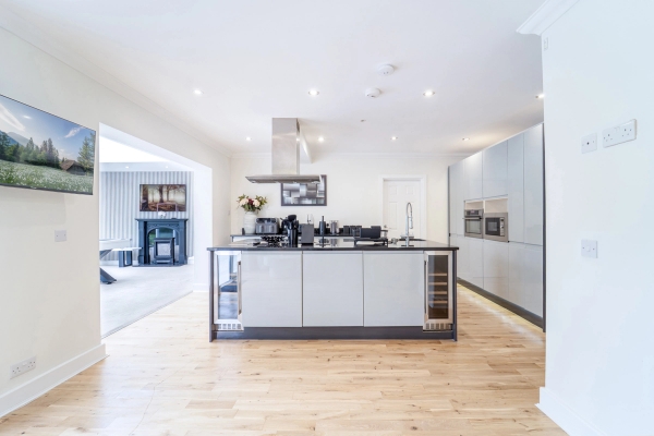 Modern luxury mansion shoot location in Emerson Park, RM11 featuring a white kitchen island with marble countertops and wood flooring via Love Locations.