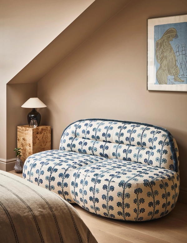 Attic bedroom reading corner featuring a patterned floral loveseat sofa set under sloped roof ceilings, Love Locations SE21.