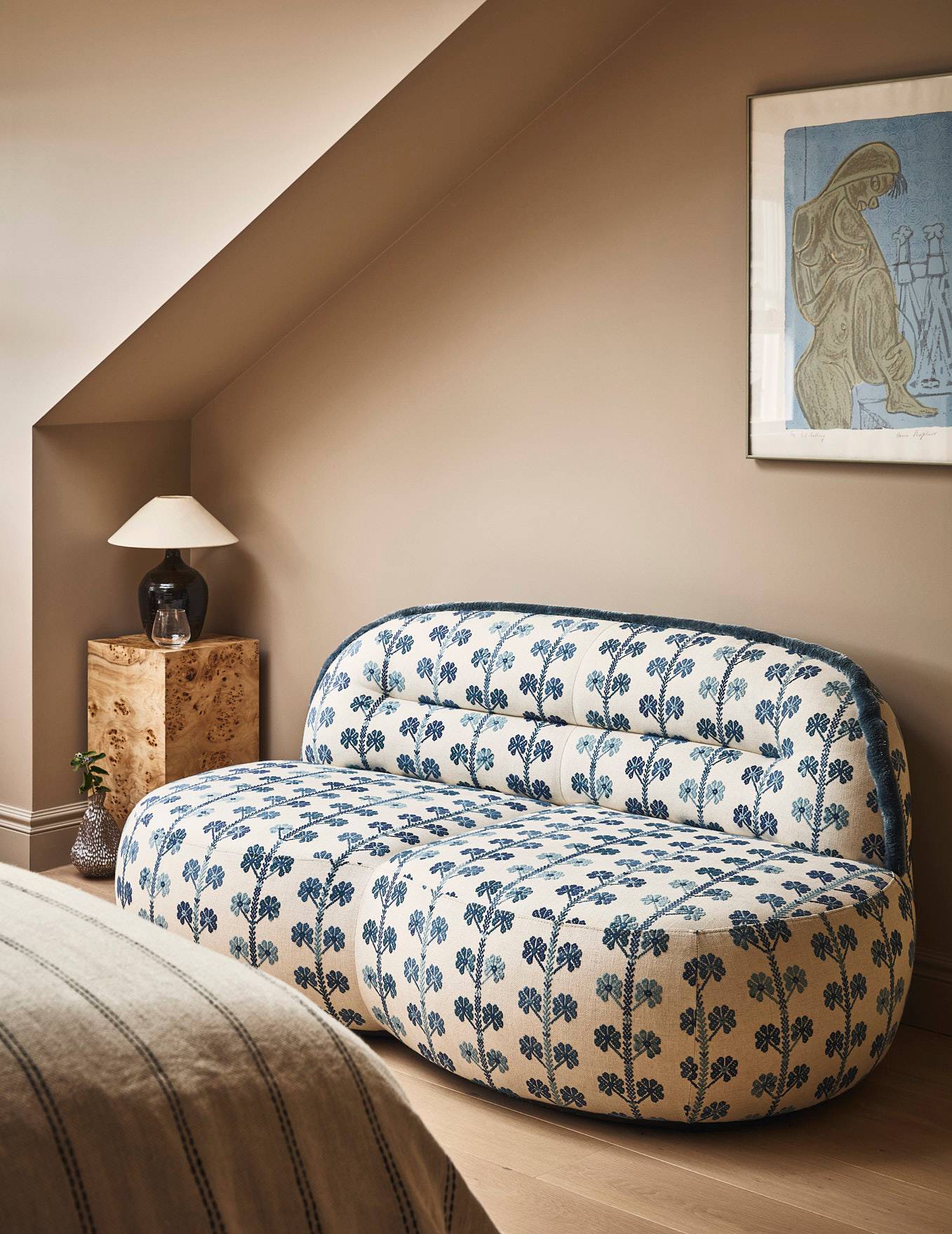 Attic bedroom reading corner featuring a patterned floral loveseat sofa set under sloped roof ceilings, Love Locations SE21.