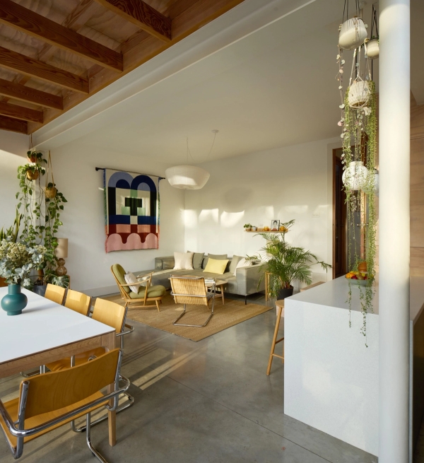 Open perspective looking across a polished concrete floor living space towards a timber dining extension, Love Locations E17.