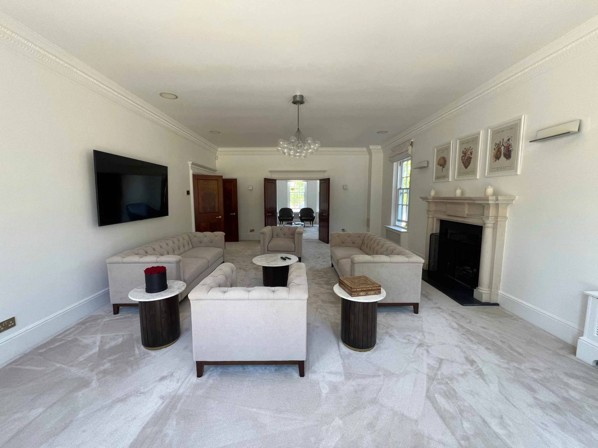 Spacious formal reception room featuring plush beige sofas, stone fireplace surround, and sash windows, Love Locations BR7.