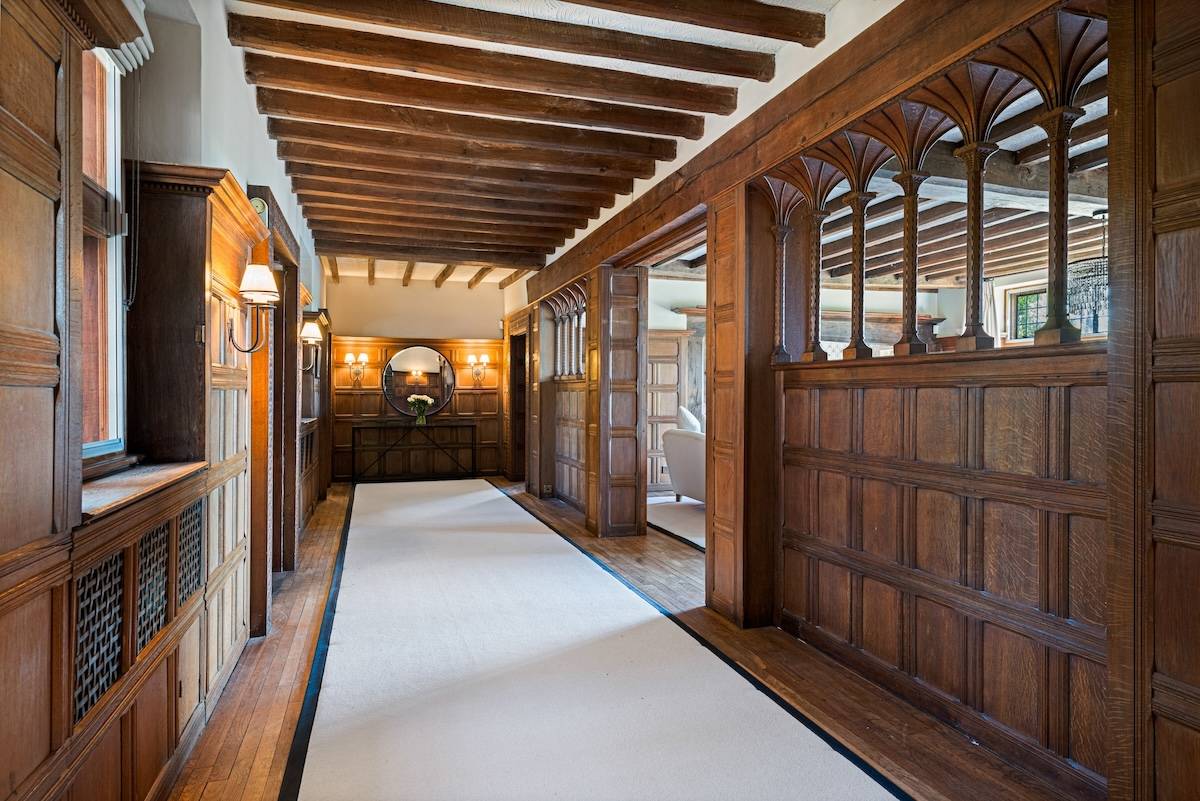 Historic oak-panelled reception corridor with exposed ceiling beams and runner carpet in Horsham, Love Locations RH13.
