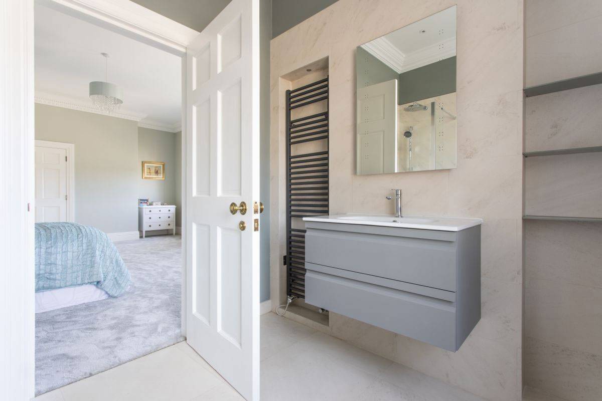 Contemporary master bathroom featuring a floating grey vanity unit and heated towel rail, premium filming location by Love Locations.