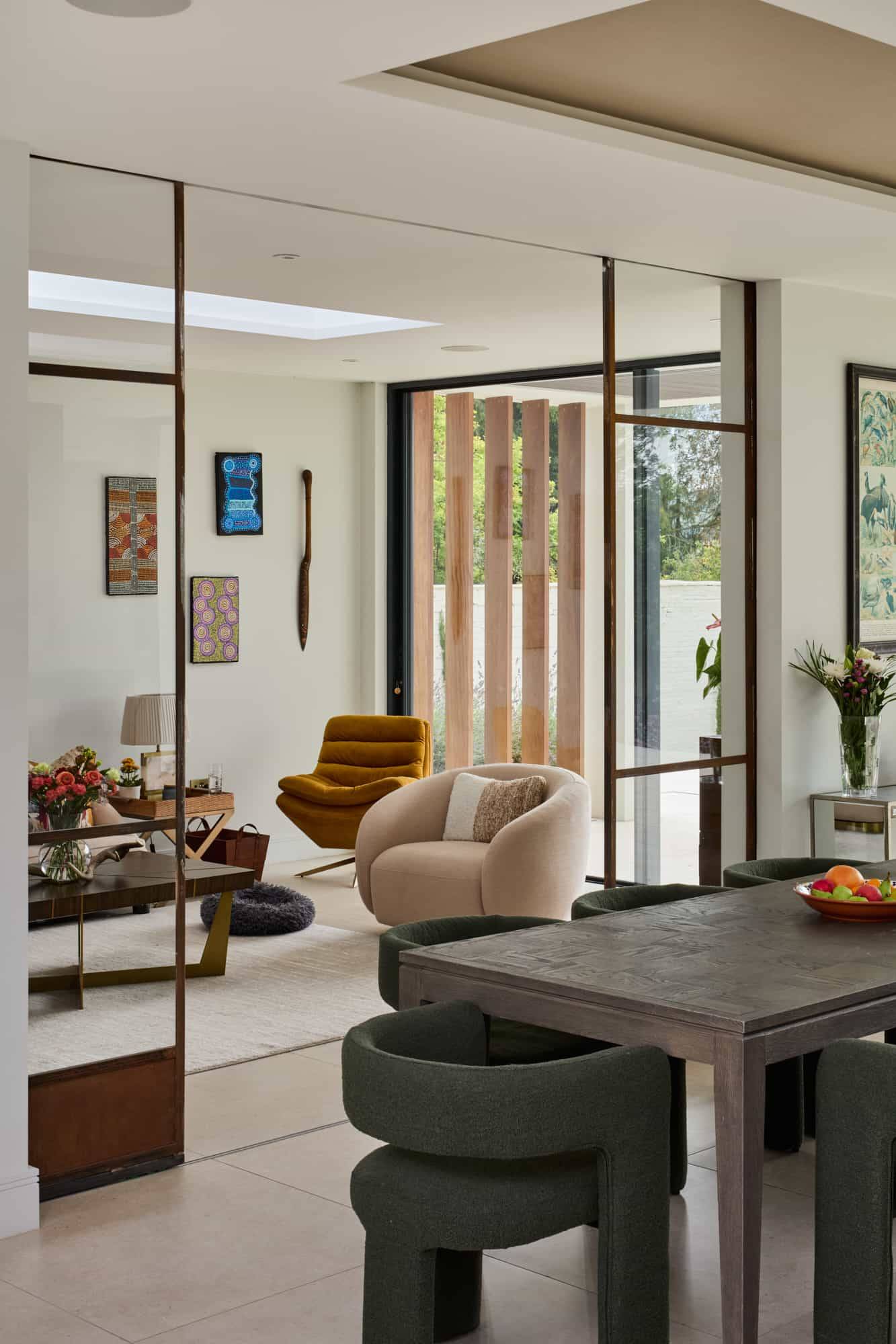 Framed view from an open-plan kitchen looking into a sunlit lounge and internal glass courtyard, perfect for commercial film backdrops, Love Locations.