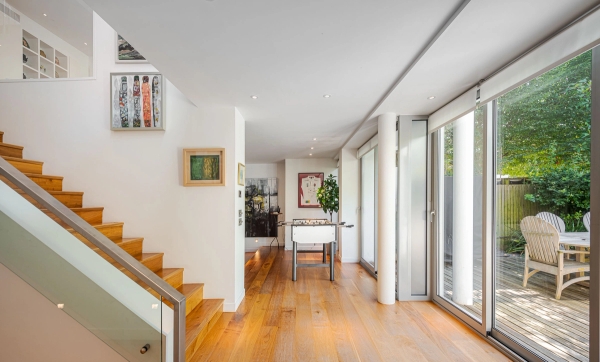 Spacious open hallway transition zone highlighting a feature staircase and bright window openings, perfect for high-fashion apparel backgrounds, Love Locations.