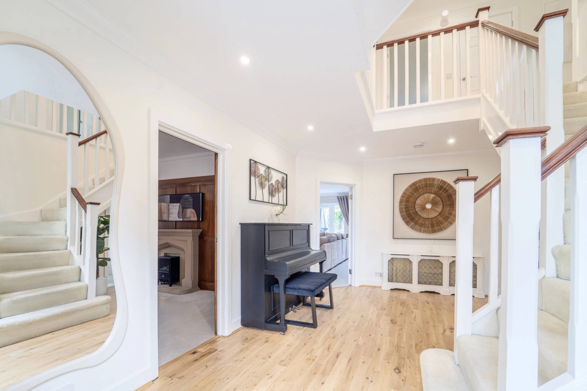 Grand entrance hall with an upright black piano, light wood flooring, and neutral walls, Love Locations RM11.